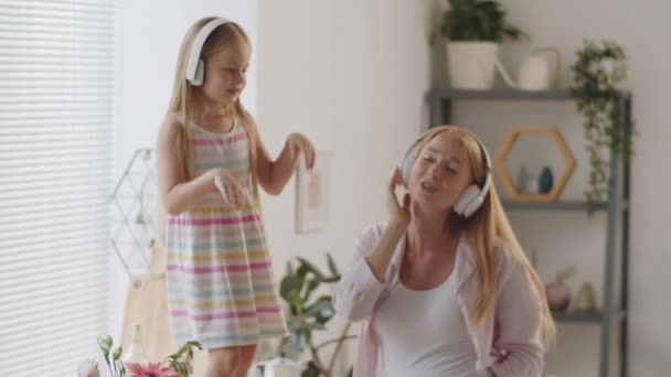 Gioiosa Bambina Cuffie Wireless Piedi Sul Tavolo Della Cucina Cantando — Video Stock