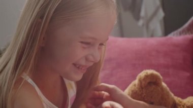 Küçük sevimli bir kızın mutlu annenin karnına parmağıyla kırmızı kalbi boyarken çekilmiş el kamerası görüntüsü.