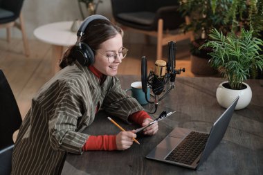 Kadın gazeteci bilgisayarda röportaj yapıyor.