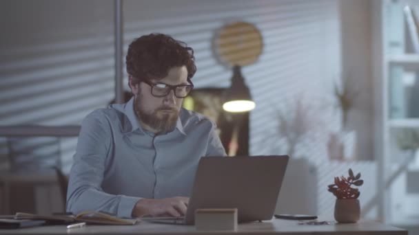 Rastreamento Tiro Empresário Exausto Com Barba Trabalhando Laptop Escritório Escuro — Vídeo de Stock