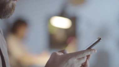 Ofiste geç saatlere kadar çalışırken cep telefonu kullanan ve gülümseyen sakallı neşeli bir adamla takibe gittim.