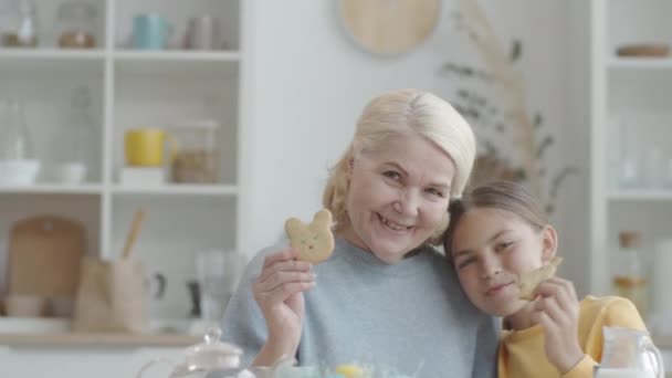 Sorridente Donna Anziana Possesso Biscotto Pasqua Abbracciando Nipotina Posa Fotocamera — Video Stock