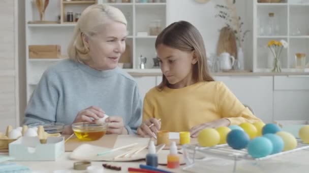 Senior Nonna Sorridente Spiegando Alla Bambina Come Tingere Uovo Pasqua — Video Stock