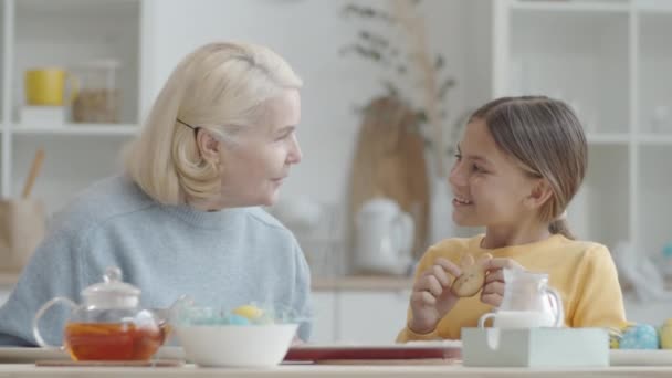 Χαριτωμένο Κορίτσι Τρώει Νόστιμο Κουνέλι Μπισκότο Και Χαμογελώντας Ακούγοντας Γιαγιά — Αρχείο Βίντεο