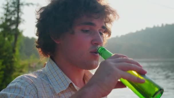 Ung Positiv Kaukasisk Man Med Lockigt Hår Dricka Från Flaska — Stockvideo