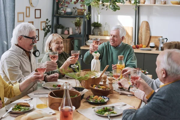 Personas mayores bebiendo vino en la cena — Foto de Stock