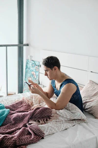 Hombre usando el teléfono en la cama — Foto de Stock