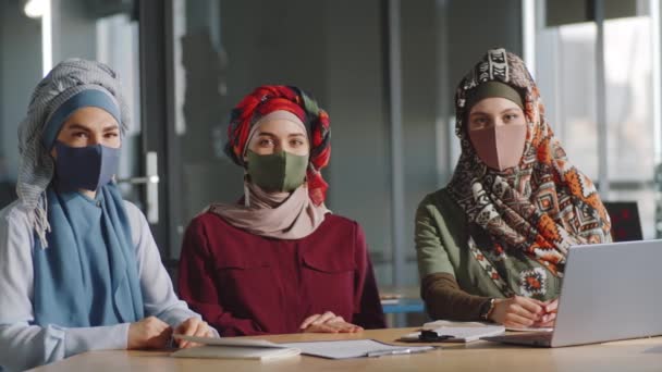 Retrato Tres Jóvenes Empresarias Musulmanas Hiyabs Máscaras Faciales Sentadas Mesa — Vídeos de Stock