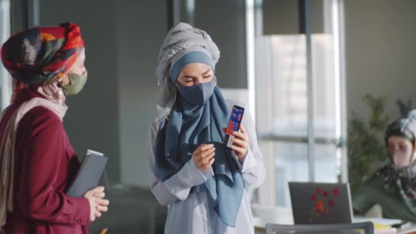 Muzułmańska Bizneswoman Hidżabie Maska Twarzy Stojąca Biurze Dyskutująca Prezentację Smartfonie — Wideo stockowe