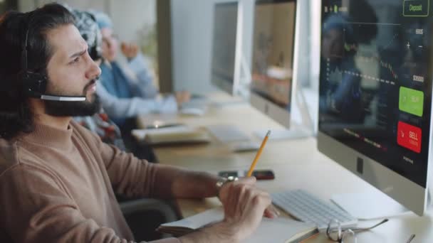 Hombre Negocios Oriente Medio Auriculares Inalámbricos Mirando Gráficos Financieros Pantalla — Vídeos de Stock