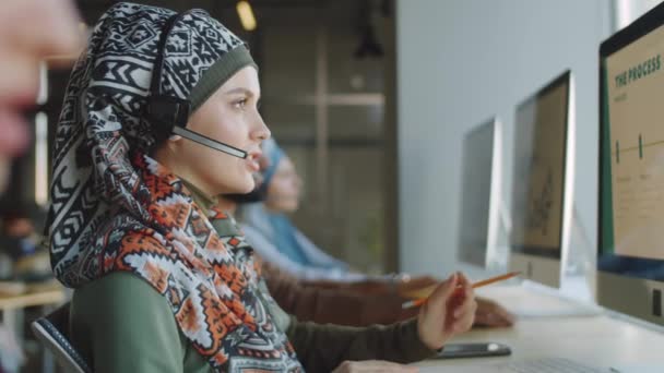 Zijaanzicht Van Moslim Vrouw Draadloze Headset Zoek Naar Computerscherm Praten — Stockvideo