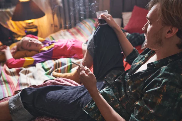 Чоловік з цигаркою і випив вдома — стокове фото
