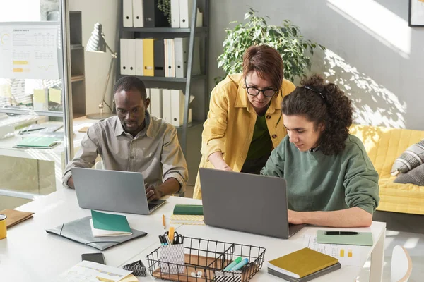 Enseignant travaillant avec des étudiants au bureau — Photo