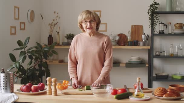 Mujer Mayor Mirando Cámara Explicando Cómo Cortar Pepino Fresco Mientras — Vídeo de stock