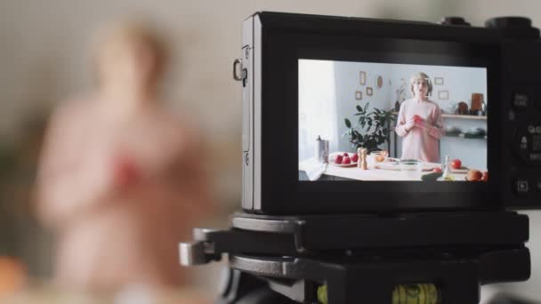 数码相机拍摄高级妇女在网上烹饪课上解释食物配方的选择性聚焦镜头 — 图库视频影像