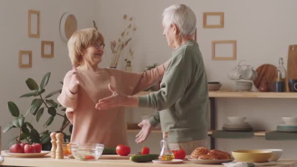 Glückliche Seniorin Und Ehemann Kochen Gemeinsam Essen Und Tanzen Dann — Stockvideo