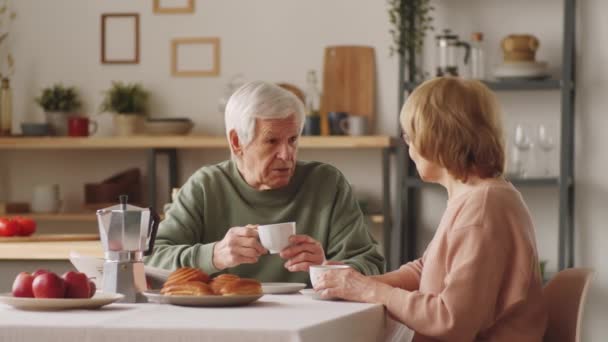 Casal Idosos Positivos Bebendo Café Sorrindo Conversando Mesa Cozinha Enquanto — Vídeo de Stock