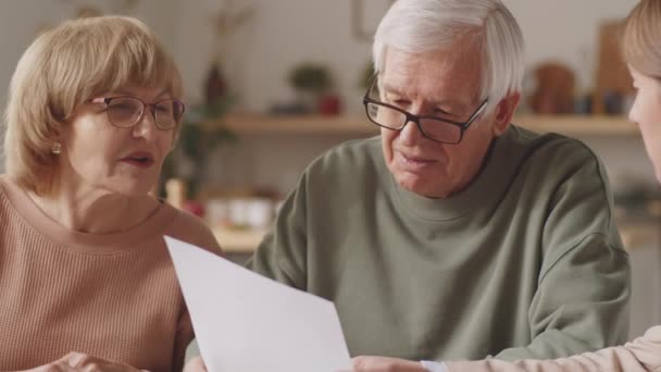 Kvinnlig Försäkringsagent Förklara Avtal Detaljer Och Tala Med Äldre Par — Stockvideo