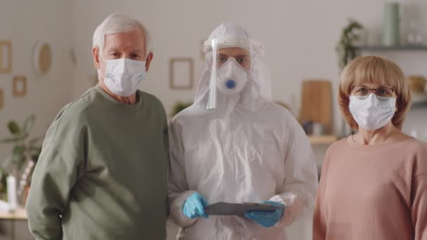 Elderly Couple Face Masks Female Doctor Protective Suit Standing Together — Stock Video