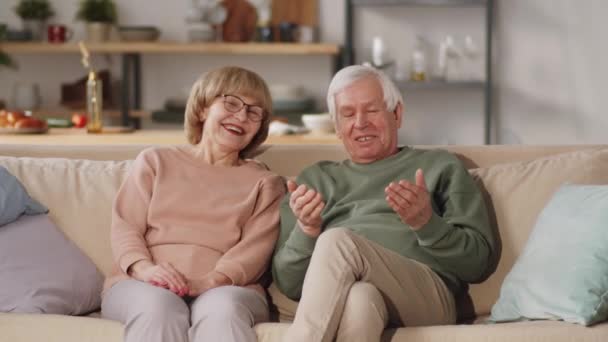 Média Foto Casal Idoso Feliz Sentado Sofá Casa Rindo Abraçando — Vídeo de Stock