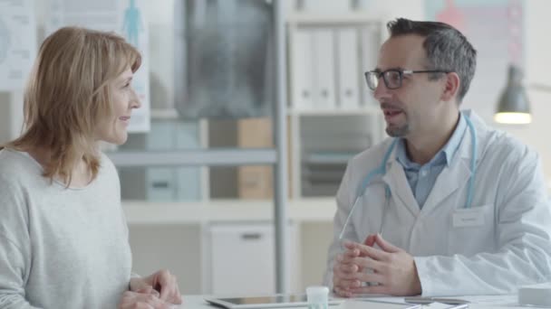 Médico Varón Con Bata Laboratorio Gafas Que Habla Con Una — Vídeo de stock