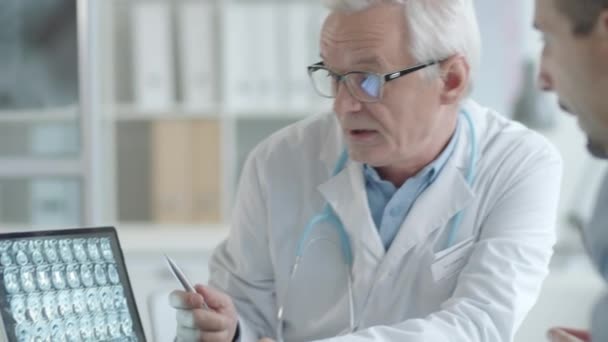 Oudere Arts Toont Röntgenbeeld Van Hersenen Laptop Praten Met Mannelijke — Stockvideo