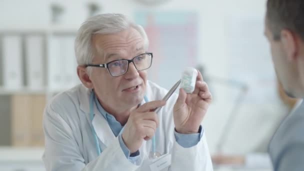 Ervaren Senior Arts Die Uitlegt Hoe Hij Medicijnen Naar Mannelijke — Stockvideo