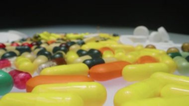 Çeşitli renkli hapları, tıbbi kapsülleri ve tabletleri stüdyodaki sehpanın üstündeki su toplama paketlerinde büyüt.