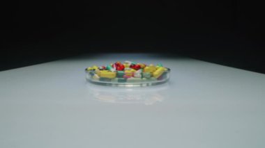 Rengarenk haplar ve kapsüllerle cam kapları yakınlaştır. Tıbbi ve sağlık hizmeti kavramı