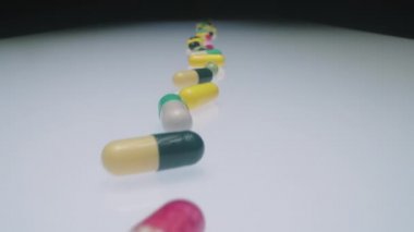 İlaç laboratuarındaki beyaz cam masa üzerinde çeşitli ilaç hapları ve kapsülleri yakınlaştır.