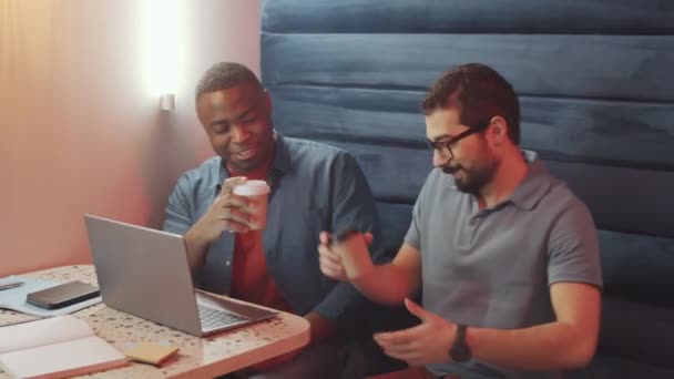 Bliskowschodni Mężczyzna Przynoszący Kawę Afroamerykaninowi Męskiemu Koledze Pracującemu Razem Nowoczesnej — Wideo stockowe