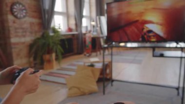 Evde birlikte video oyunu oynarken kontrol cihazı kullanan ve genç kız kardeşiyle konuşan bir çocuk.