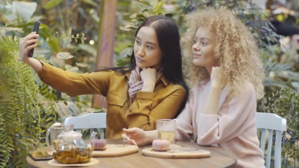 Fiatal Ázsiai Okostelefont Használ Szelfit Készít Szőke Barátnőjével Majd Fényképet — Stock videók