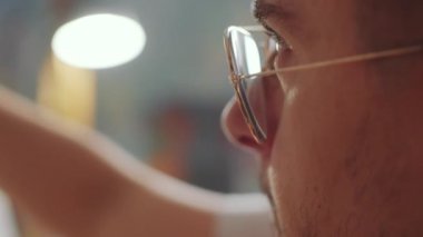 Stüdyoda resim yapan genç bir erkek sanatçının aşırı yakın çekimi.