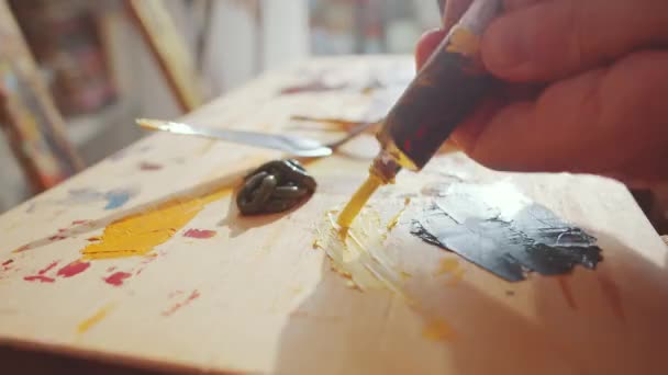 Close Tiro Mãos Artista Espremendo Tinta Amarela Tubo Paleta Madeira — Vídeo de Stock