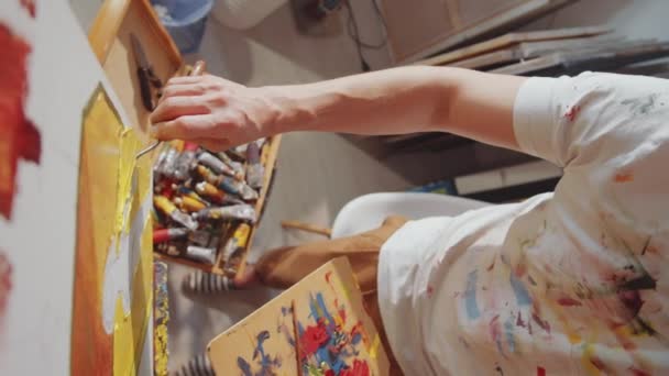 Hochwinkelaufnahme Eines Jungen Männlichen Künstlers Gebeiztem Shirt Malerei Auf Leinwand — Stockvideo