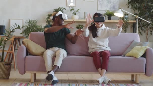 Joven Pareja Multiétnica Con Auriculares Sentados Sofá Casa Sonriendo Mirando — Vídeos de Stock