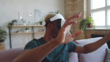 Kamerada, VR gözlüklü gülümseyen siyah adamın evdeki koltukta oturduğu ve artırılmış gerçekliği deneyimlerken havada bir şeye dokunduğu görüntüler var.