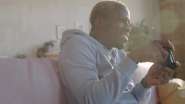 Junger Aufgeregter Schwarzer Mann Sitzt Hause Auf Sofa Und Benutzt — Stockvideo