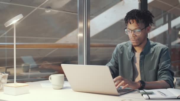 Foto Rastreamento Jovem Empresário Afro Americano Digitando Laptop Usando Smartphone — Vídeo de Stock