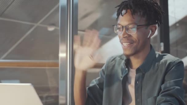 Joven Hombre Afroamericano Poniendo Auriculares Inalámbricos Saludando Cámara Frontal Computadora — Vídeos de Stock
