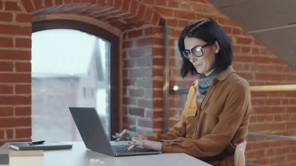 Hermosa Mujer Negocios Morena Traje Casual Gafas Escribiendo Portátil Sonriendo — Vídeo de stock