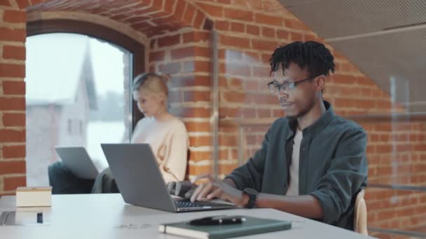 Jonge Afro Amerikaanse Man Typt Laptop Het Bureau Loft Kantoor — Stockvideo
