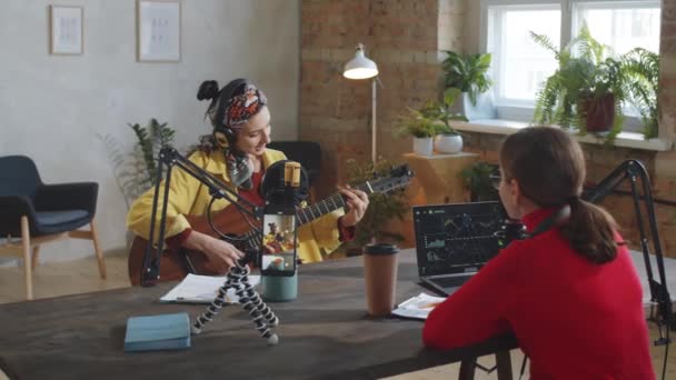 Mladá Krásná Žena Sluchátkách Hraje Kytaru Zpívá Mikrofonu Pak Usmívá — Stock video