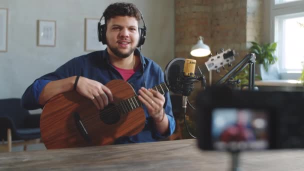 Mladý Pozitivní Samec Vlogger Sluchátkách Mává Mluví Mikrofonu Demonstruje Jak — Stock video