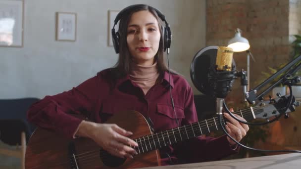 Perempuan Cantik Musisi Headphone Melihat Kamera Bermain Gitar Dan Berbicara — Stok Video