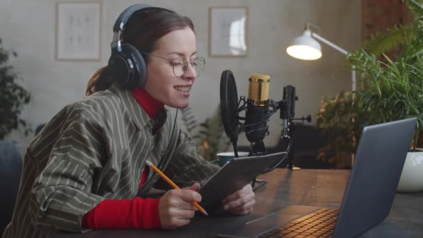 Positive Kaukasische Frau Mit Kopfhörern Liest Rede Aus Papier Auf — Stockvideo