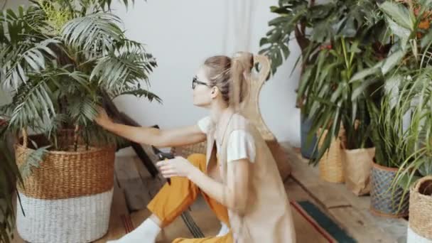 Молодая Женщина Сидящая Полу Использующая Ручные Обрезки Обрезки Хамедорейской Ладони — стоковое видео