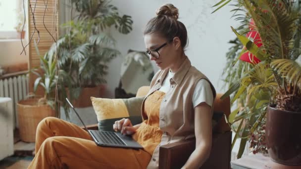 Genç Kafkasyalı Kadın Koltuğunda Oturuyor Dizüstü Bilgisayarını Kullanıyor Tropikal Bitkilerle — Stok video