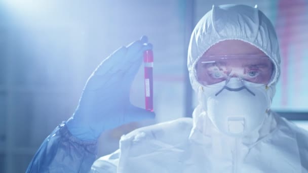 보호용 마스크 장갑을 실험실 과학자의 가슴을 Covid 시험관을 자신있게 카메라를 — 비디오